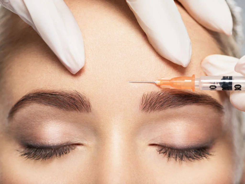 A close-up of a woman receiving a forehead injection, highlighting the differences and benefits of Dysport and Botox treatments.