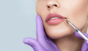 A close-up of a woman's lips receiving a cosmetic injection, showcasing the difference between lip flip and lip filler for enhancing lip volume and shape.